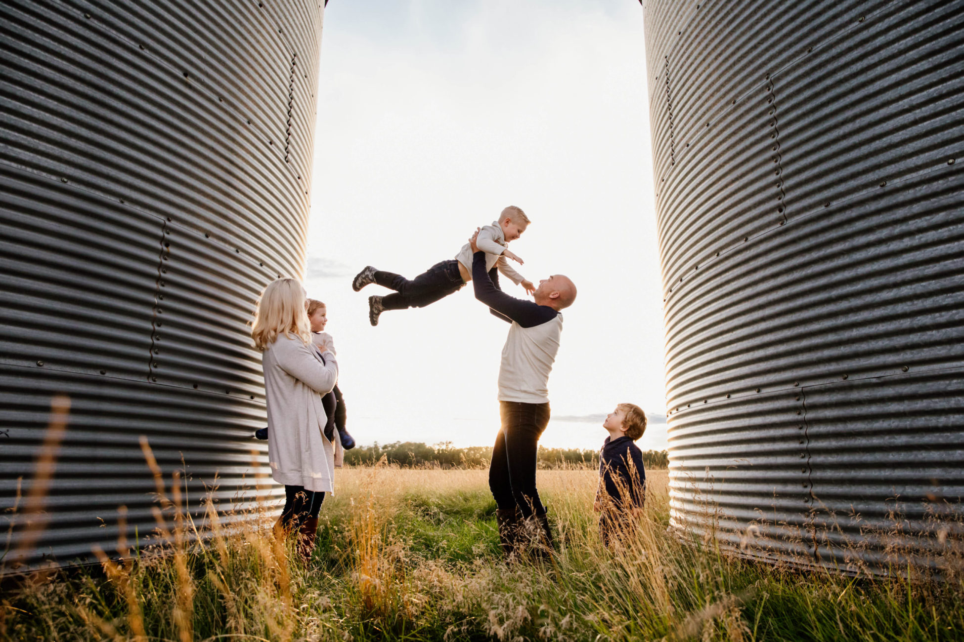 Playful family photographed on prairie farm